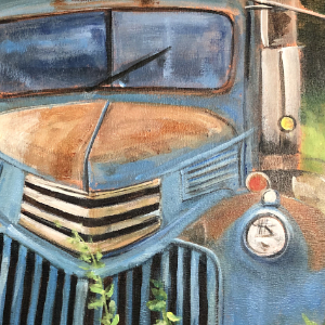 Rusty old blue truck abandonded in a field.