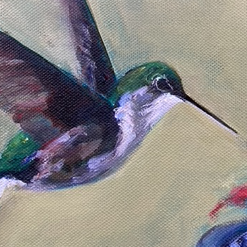 Purple and green hummingbird hovering near a red feeder.
