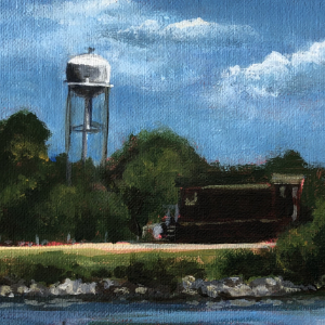 A train travels across a pond of water with a water tower in the distance. It is HH Knoll Park in Port Colborne, Ontario.
