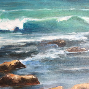 Waves rolling and crashing along the coast of Mexico. Rocks and a bit of sand are in the foreground while the green and blue waves  capped with white foam are most predominant.