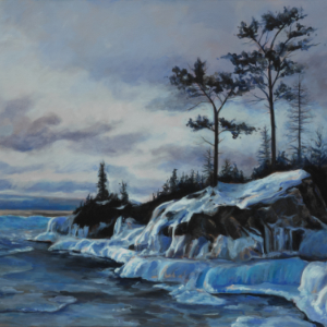 Winter scene of rocky shore with some trees at sunset. The time is dusk when the light is low but not quite dark yet.